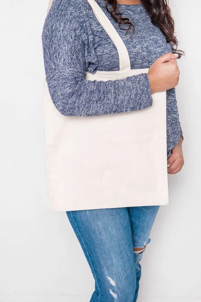 空繊維袋を保持しているジーンズの女性 デザインのモックアップ — ストック写真