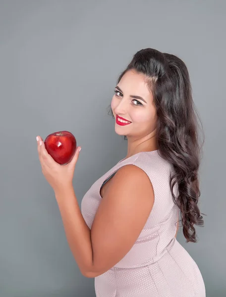 Apple と灰色の背景で幸せなプラスのサイズの女性 — ストック写真