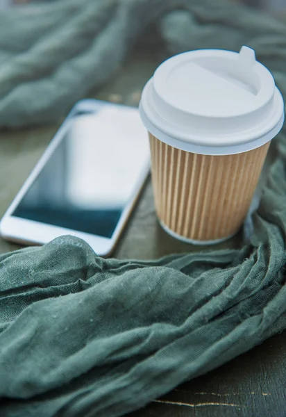 Papierowy Kubek Kawy Zielony Szalik Telefon Komórkowy Podłoże Drewniane — Zdjęcie stockowe