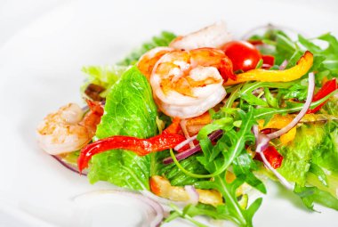 Lezzetli salata karides, domates ve yeşillik beyaz arka plan üzerinde