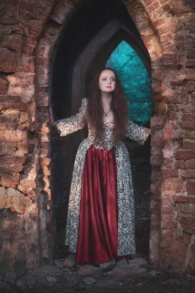 古い放棄された城の屋外で長い中世のドレスで美しい少女 — ストック写真