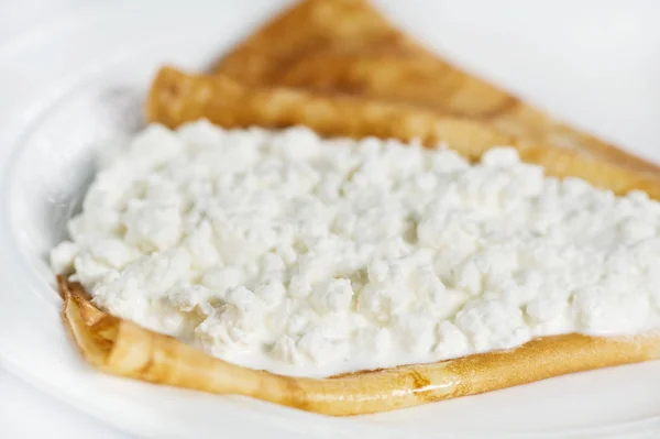 Dünne leckere Pfannkuchen mit Quark auf weiß — Stockfoto