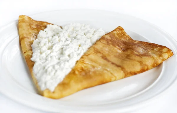 Delgado panqueque delicioso con queso cottage en blanco — Foto de Stock