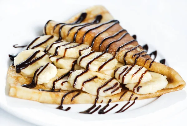 Thin delicious pancake with banana and chocolate on white — Stock Photo, Image