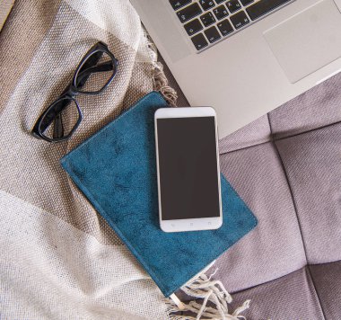 Dizüstü bilgisayar, akıllı telefon ve defter ile rahat çalışma alanı. İçin alay