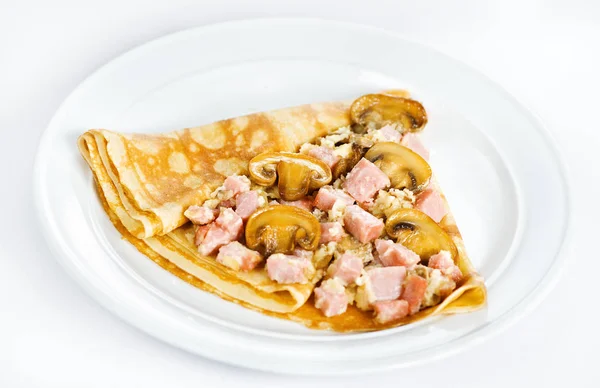 Dunne heerlijke pannenkoek met ham en paddestoelen op wit — Stockfoto