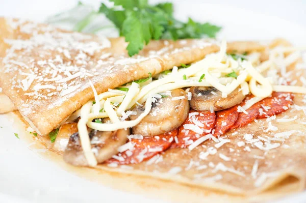 Dunne heerlijke pannenkoek met salami en champignons op wit — Stockfoto