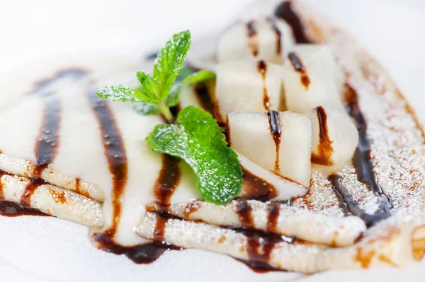 Dünne leckere Pfannkuchen mit Kondensmilch auf weißem — Stockfoto