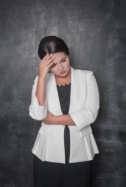 Hermosa mujer con dolor de cabeza en pizarra — Foto de Stock