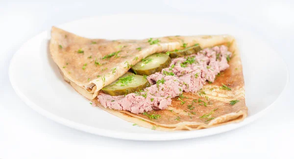 Delgado panqueque delicioso con paté de carne y pepino en blanco — Foto de Stock