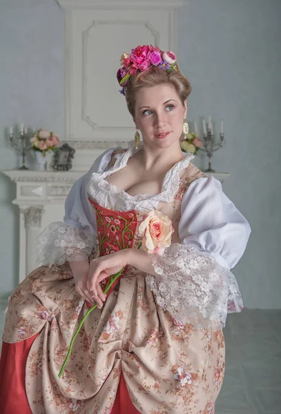 美丽的微笑的女人在中世纪礼服拿着粉红色的玫瑰 — 图库照片