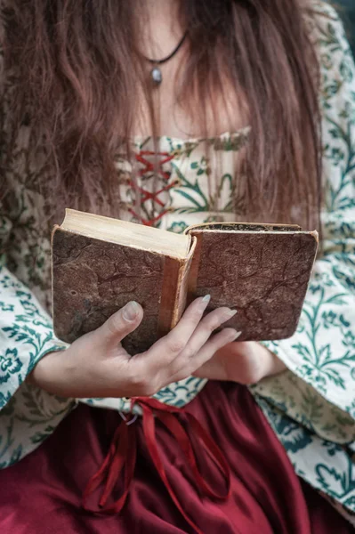 Manos de mujer en vestido medieval sosteniendo viejo libro vintage —  Fotos de Stock