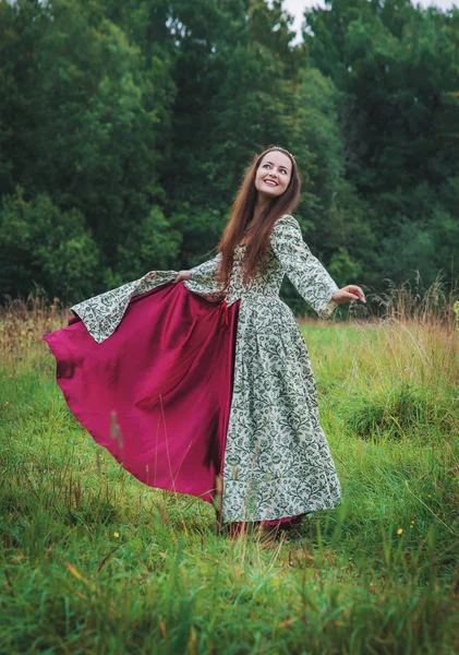 Hermosa mujer feliz en vestido medieval largo bailando —  Fotos de Stock