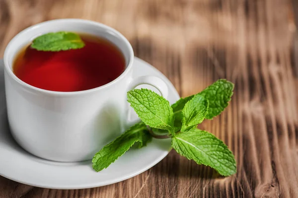 Taza con té y menta en la mesa vieja —  Fotos de Stock