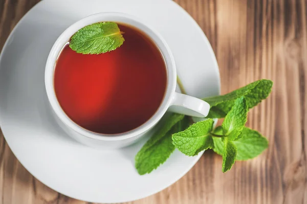 Kopje met thee en munt op de oude tafel — Stockfoto