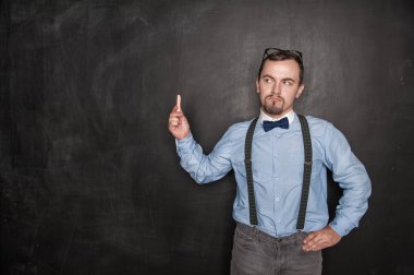 Tahta arka planda tebeşir ile düşünceli öğretmen