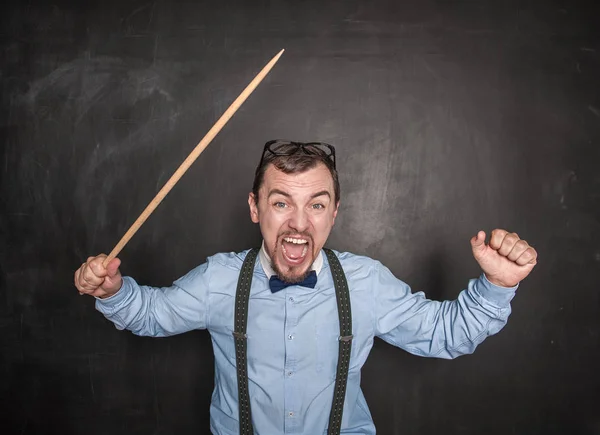 Angry screaming teacher with pointer on blackboard — Stock Photo, Image