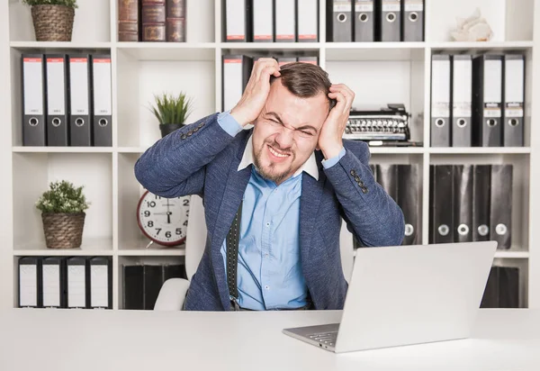 Hombre de negocios con dolor de cabeza trabajando en la oficina —  Fotos de Stock