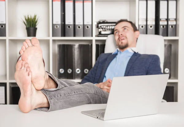 Barefoot business man relaxing in office. Focus on legs — Stock Photo, Image