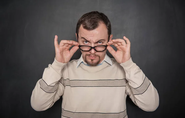 Knappe strenge leraar in brillen op zoek naar je op blackboa — Stockfoto