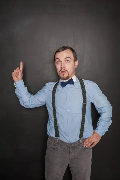 Guapo profesor apareciendo en algo por dedo en pizarra — Foto de Stock