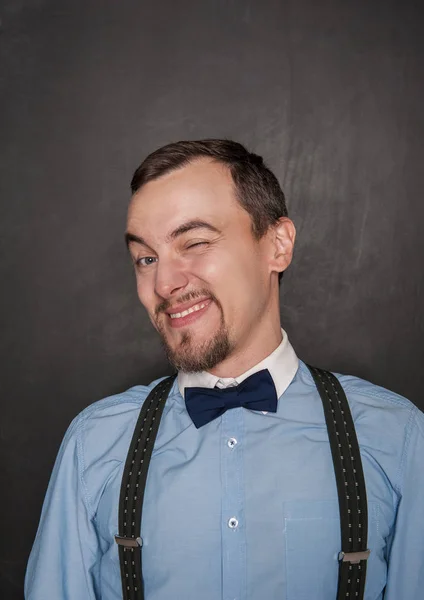 Handsome business man winking on blackboard — Stock Photo, Image