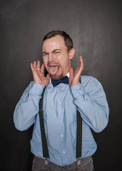 Funny business man or teacher with disgust gesture on blackboard — Stock Photo, Image
