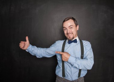 Yakışıklı gülümseyen adam blackbo elinde bir şey gösteren