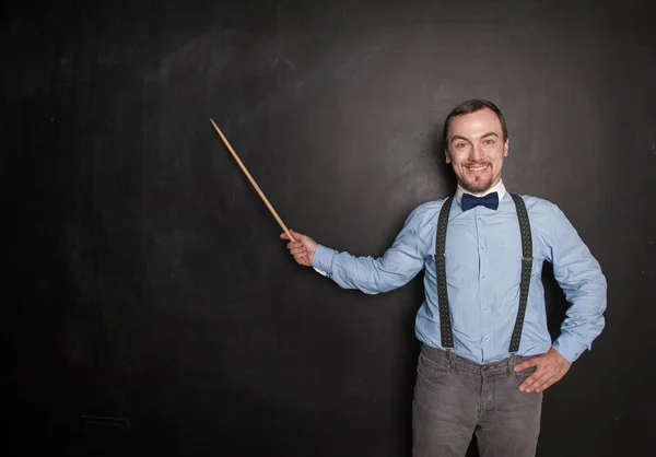 Sorrindo feliz professor homem com ponteiro no quadro negro — Fotografia de Stock