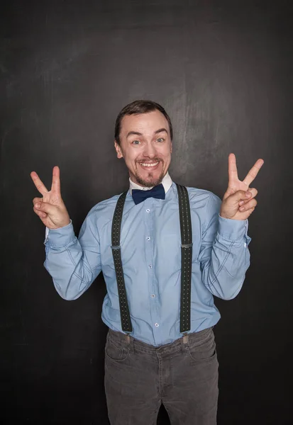 Handsome business man with victory gesture on blackboard — Stock Photo, Image