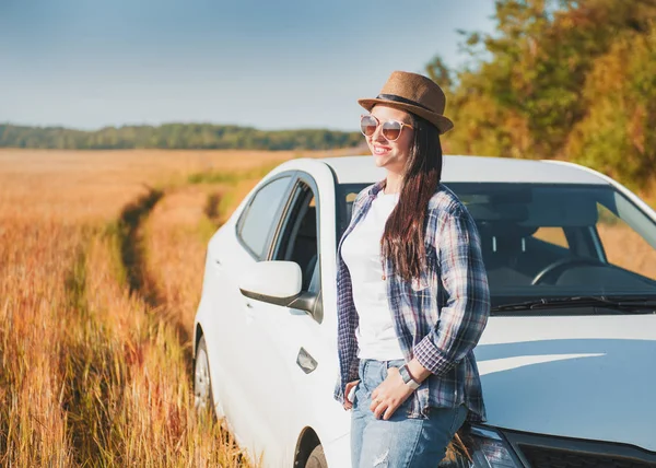 Schöne Frau mit weißem Auto auf dem Feld — Stockfoto