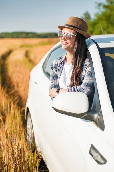 Schöne Frau mit weißem Auto auf dem Feld — Stockfoto