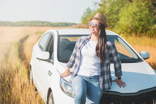 Schöne Frau mit weißem Auto auf dem Feld — Stockfoto