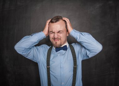 Tahta üzerinde baş ağrısı ile yakışıklı öğretmen adam 