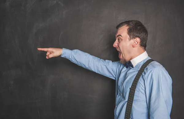 Angry screaming teacher man pointing out on blackboard