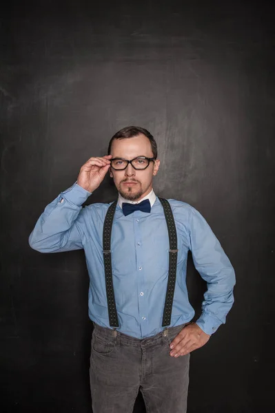 Guapo estricto maestro en gafas que te mira en blackboa — Foto de Stock