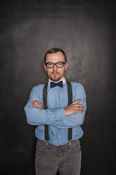 Handsome strict teacher in eyeglasses looking at you on blackboa — Stock Photo, Image