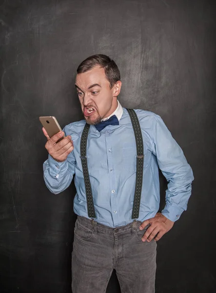 Hombre de negocios enojado con teléfono móvil en la pizarra — Foto de Stock