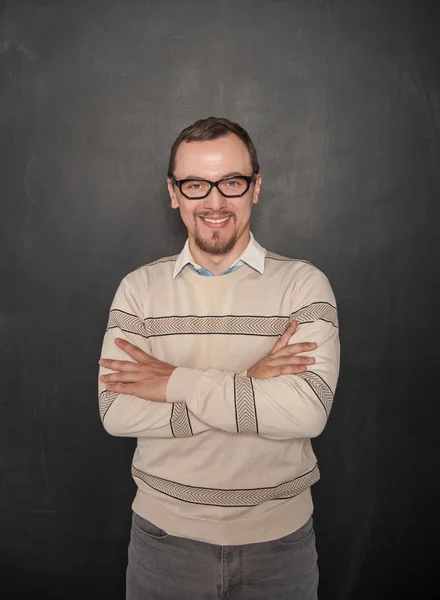 Smiling happy teacher on blackboard background — Stock Photo, Image