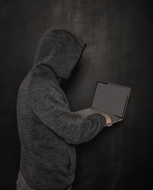 Karanlık üzerinde laptop kullanarak adam hacker programcı 