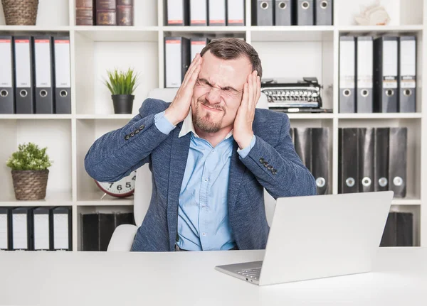 Jungunternehmer mit Stress und Kopfschmerzen im Büro — Stockfoto