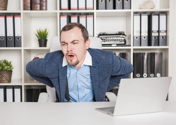 Geschäftsmann mit Rückenschmerzen bei der Arbeit im Büro — Stockfoto