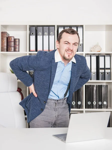 Hombre de negocios con dolor en la espalda trabajando en la oficina — Foto de Stock