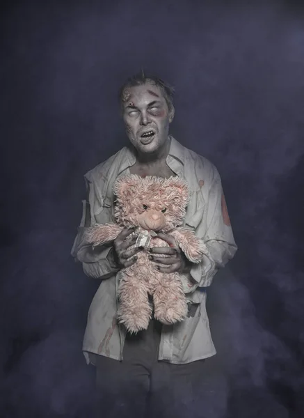 Ужасный страшный зомби-человек с плюшевым мишкой — стоковое фото