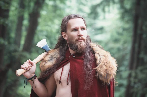 Guapo guerrero vikingo hombre con hacha de hierro al aire libre — Foto de Stock