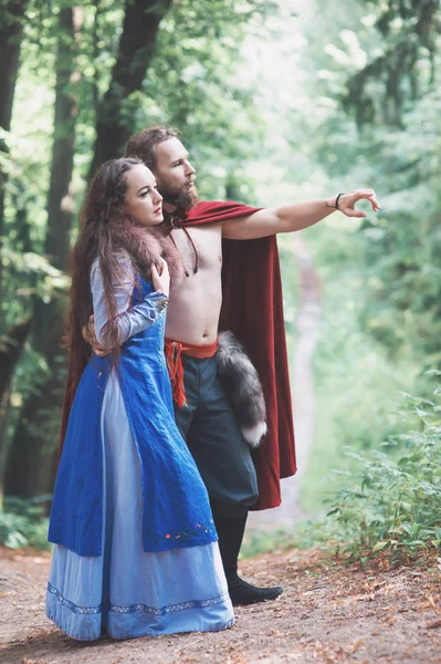 Handsome Warrior Viking man with beautiful medieval woman outdoo