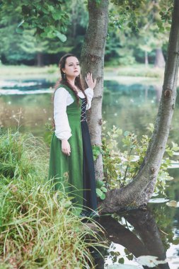 Nehir yakınında yeşil ortaçağ elbise güzel kadın 