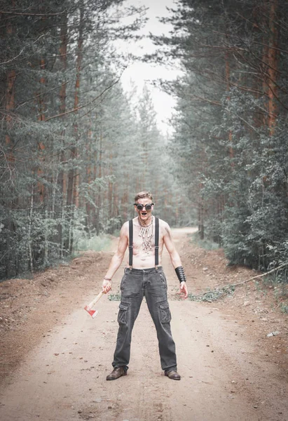 Cannibal steampunk Hombre en gafas con hacha en el bosque — Foto de Stock