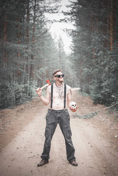 Hombre caníbal en gafas con hacha y cráneo —  Fotos de Stock