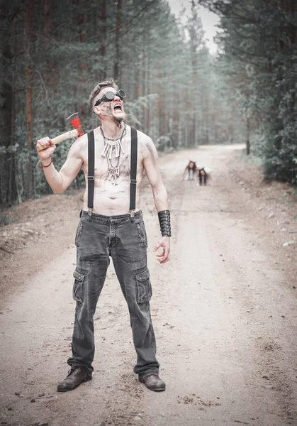 Hombre caníbal en gafas con axel y dos fantasmas en el camino — Foto de Stock